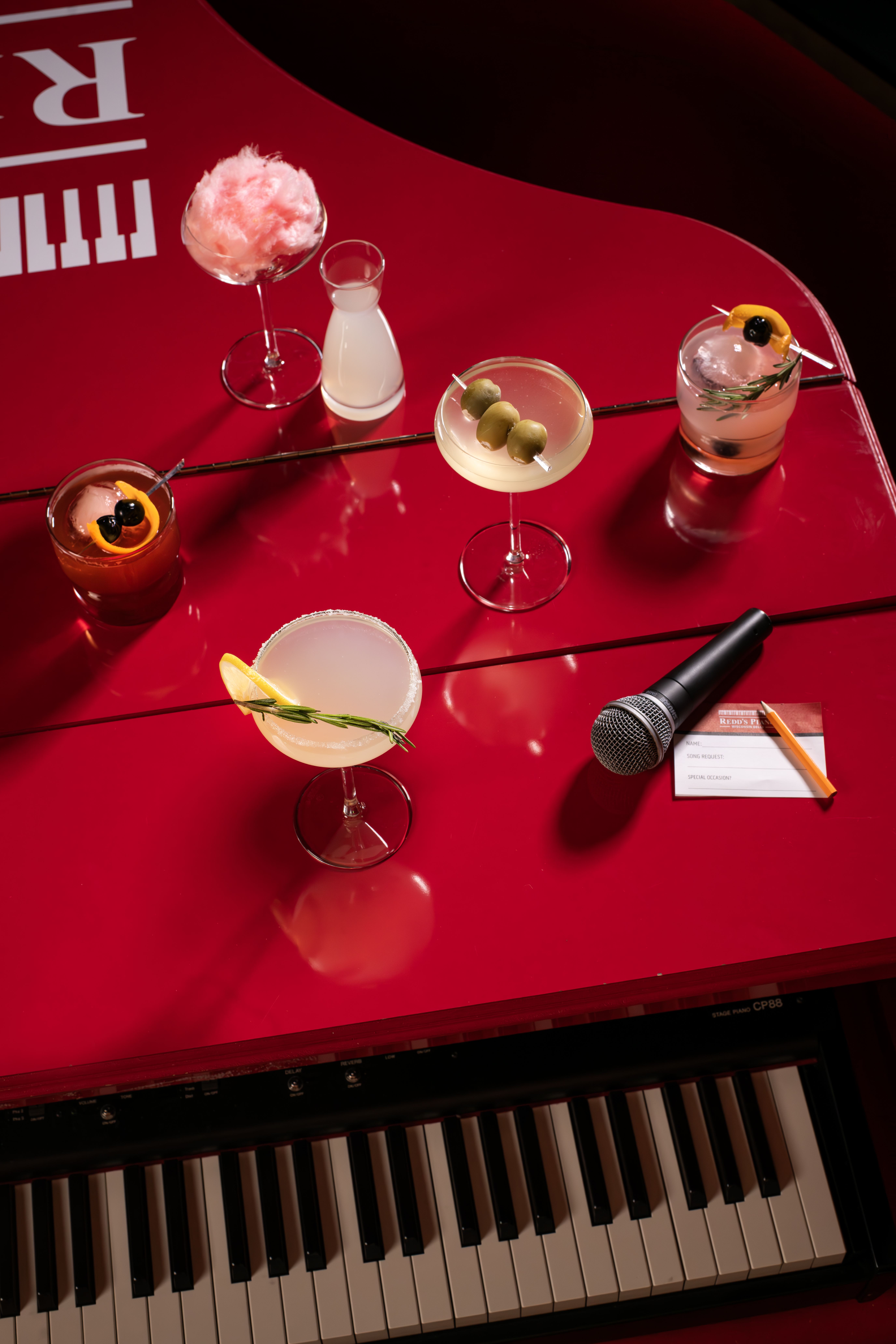 an assortment of cocktails on the piano in redd's piano bar!
