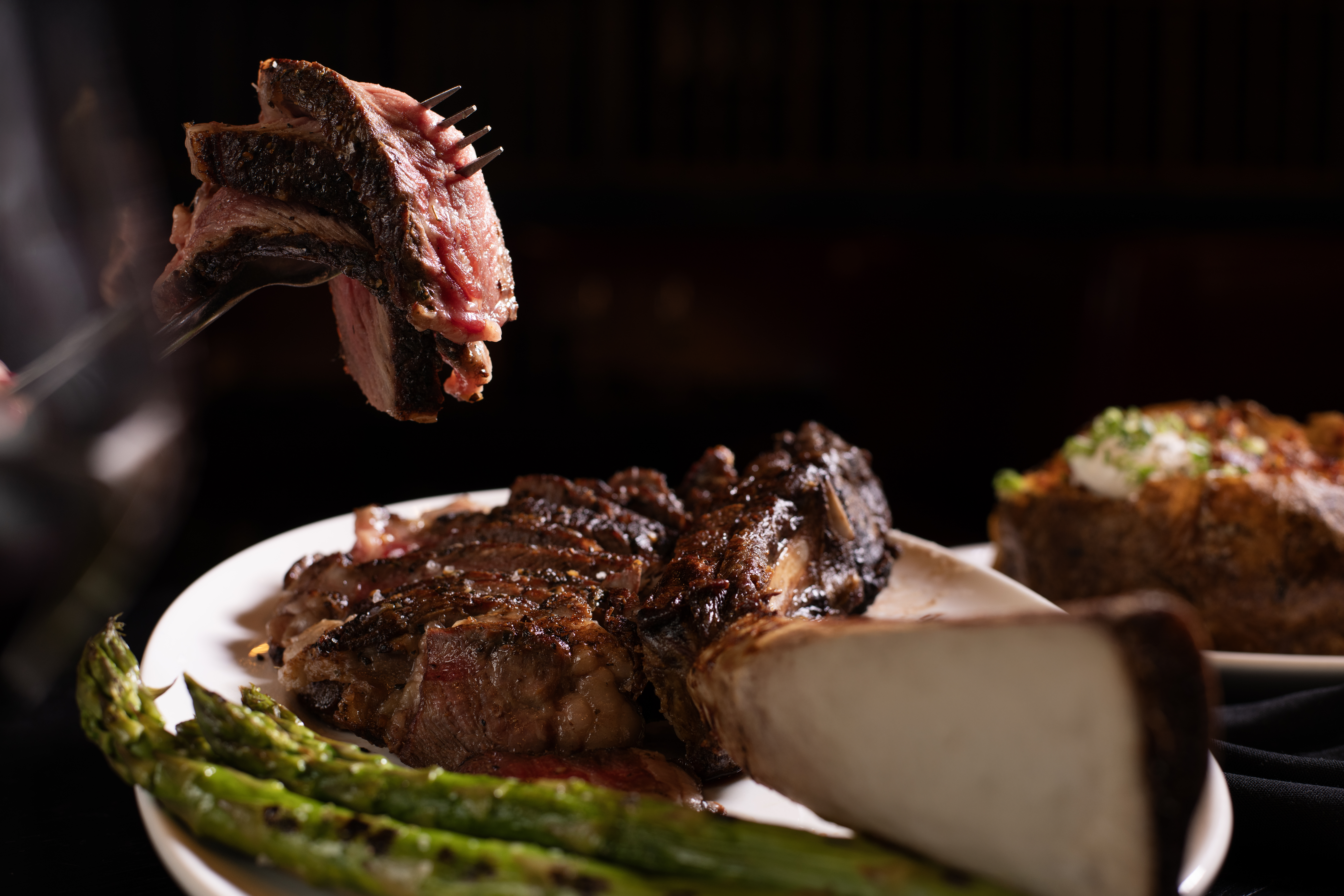 Porterhouse steak cut up with a bite on the fork